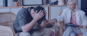 A man with a female therapist looking extremely stressed and frustrated.