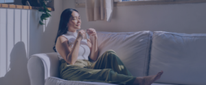 Young woman on the sofa enjoying a warm drink.